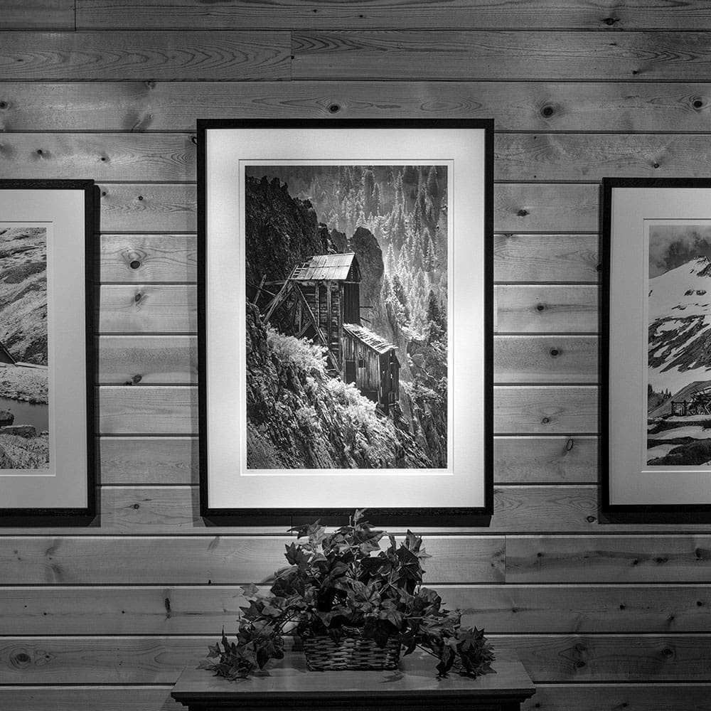 Black and white image of old mining building hung on wall.