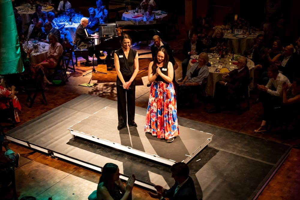 two women standing on stage