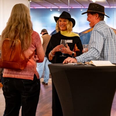 Three people standing at a cocktail table